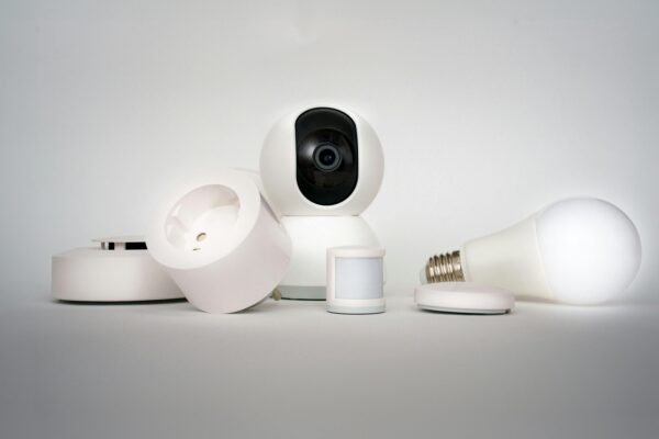 A range of smart home devices including camera and lightbulb in a minimalist setup.